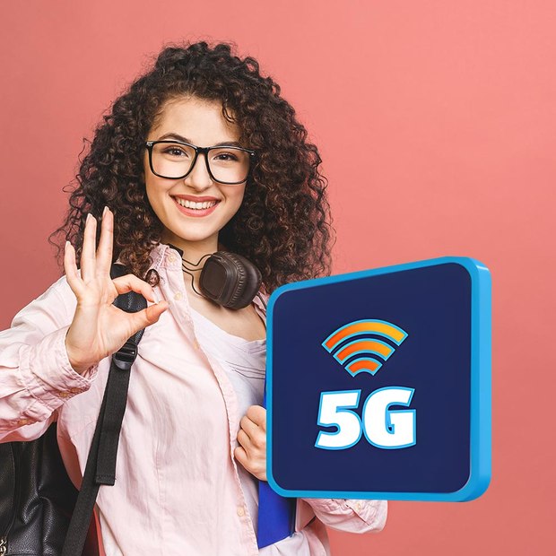 Nasmejana ženska s slušalkami kaže znak "vse je v redu" ob 3D ikoni s simbolom za WiFi in oznako 5G.